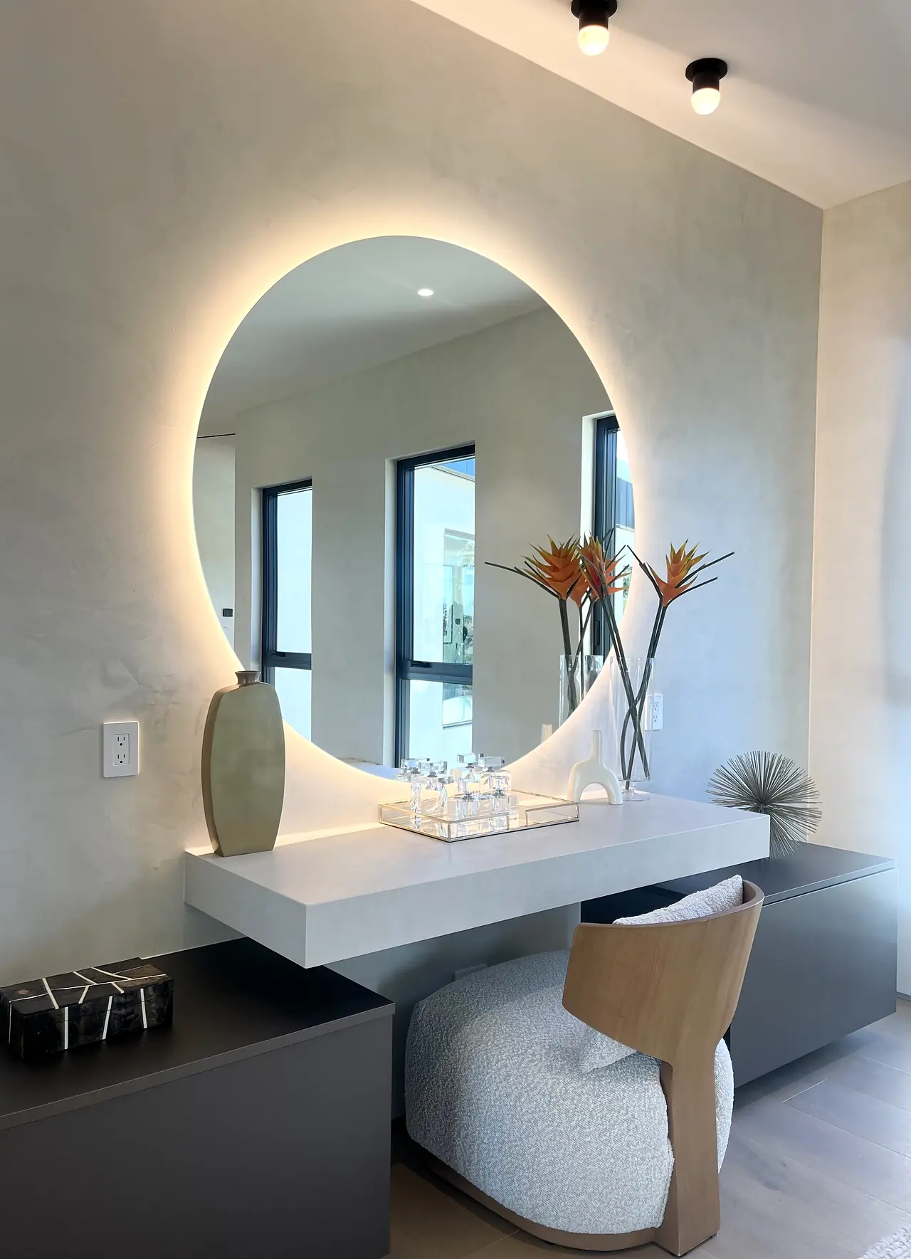 Bathroom with smooth plaster walls and a round backlit mirror