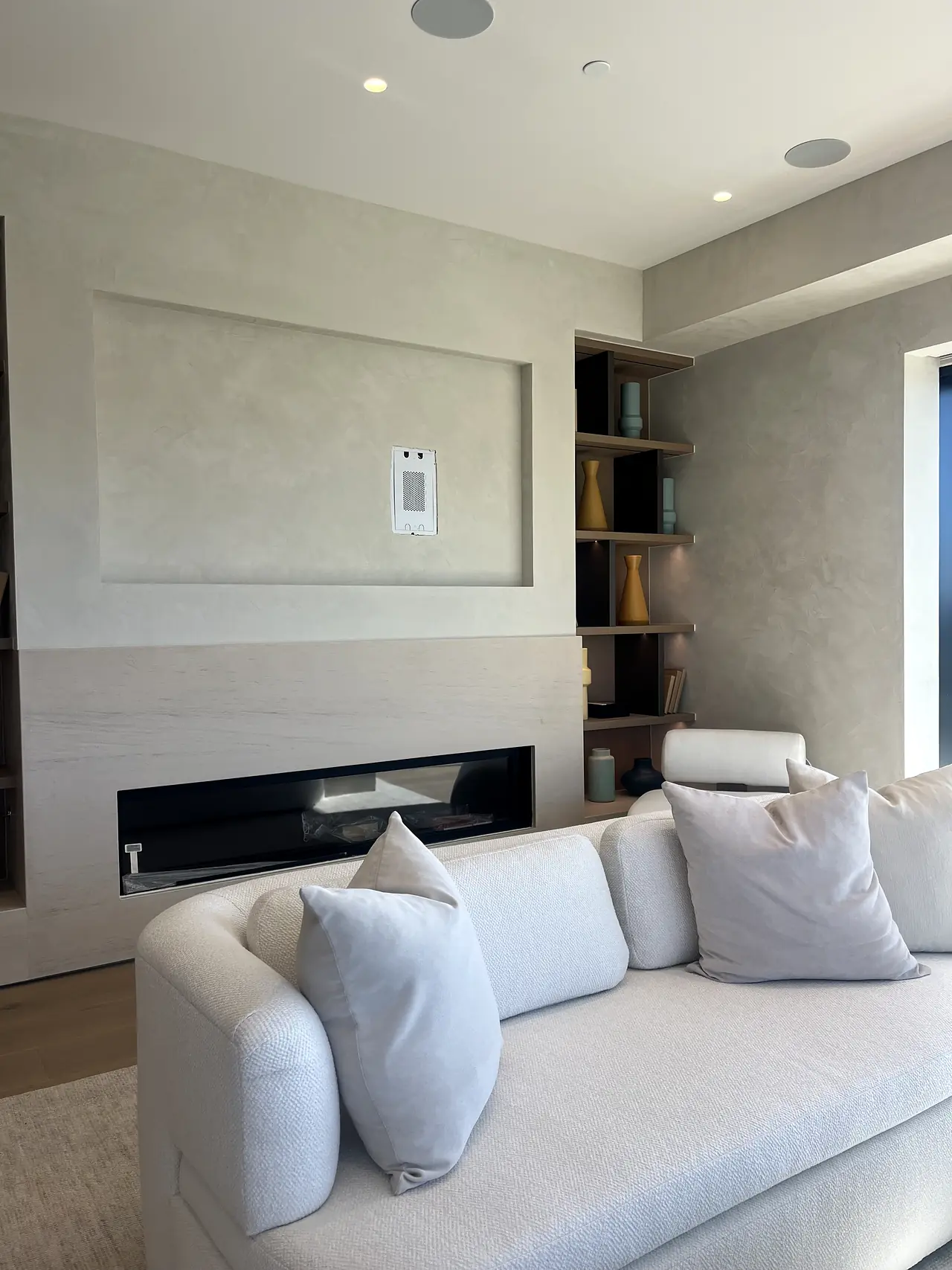 Bright living room with a plaster fireplace accent wall