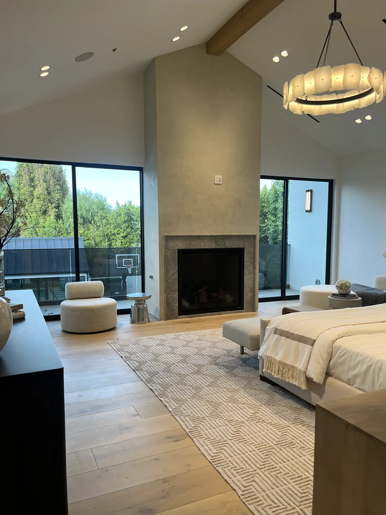 Bedroom with a smooth plaster fireplace chimney rising to a vaulted ceiling