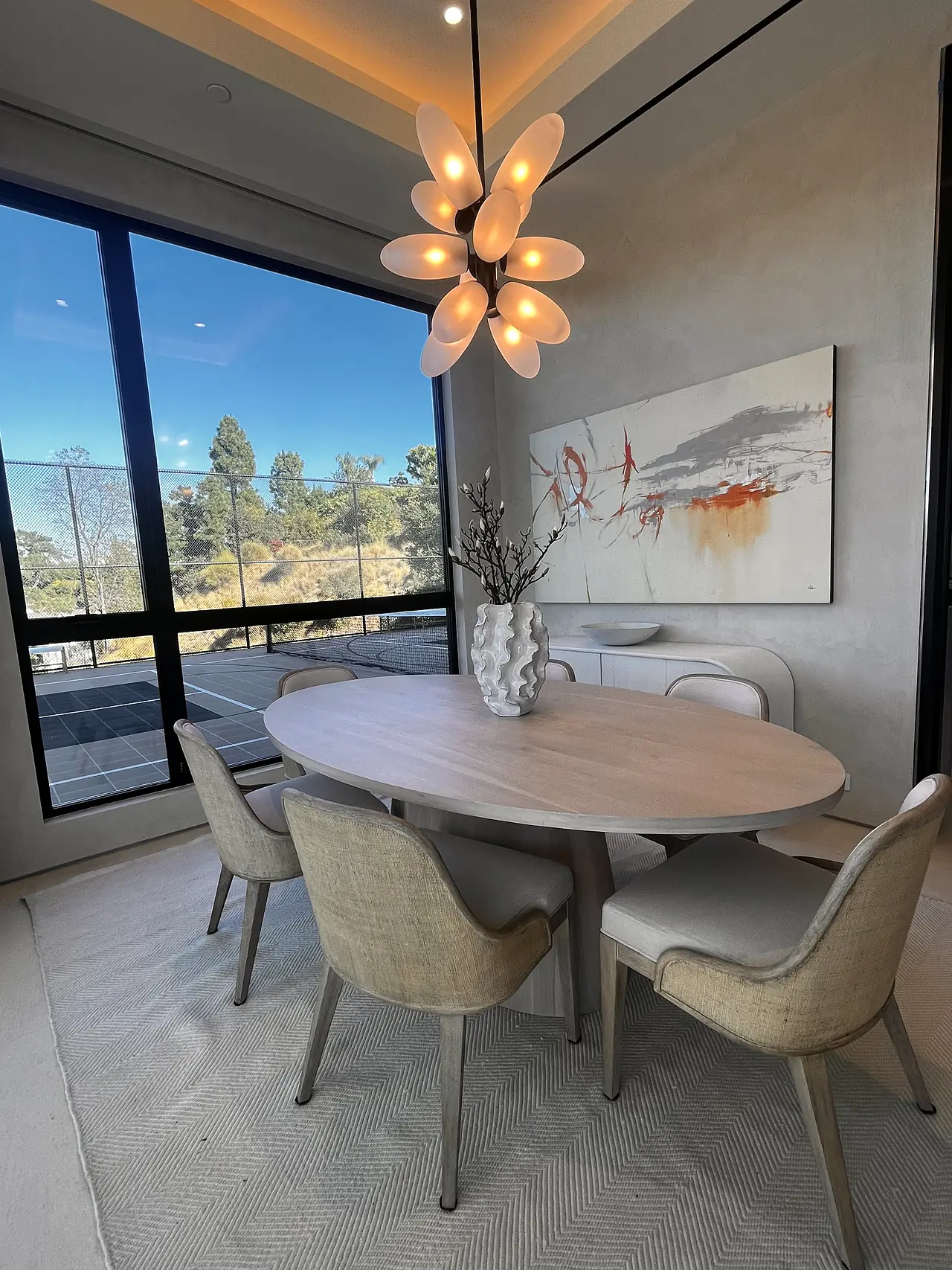 Dining room with warm, softly textured plaster walls under a sculptural chandelier